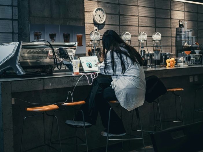 Finishing your book isn’t always glamorous: a woman writes at a bar with her laptop.