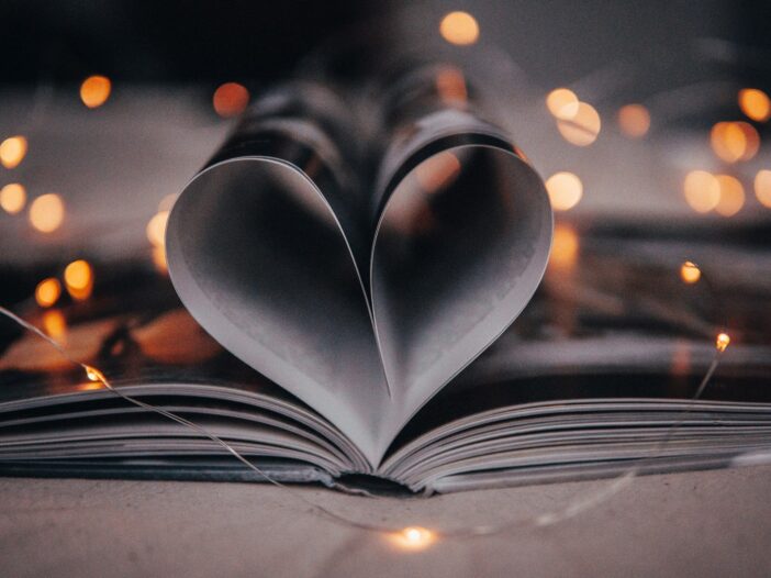 A book with its pages folded into a heart, symbolizing love, success, and the achievement of financial freedom—a 'retired my husband' moment.