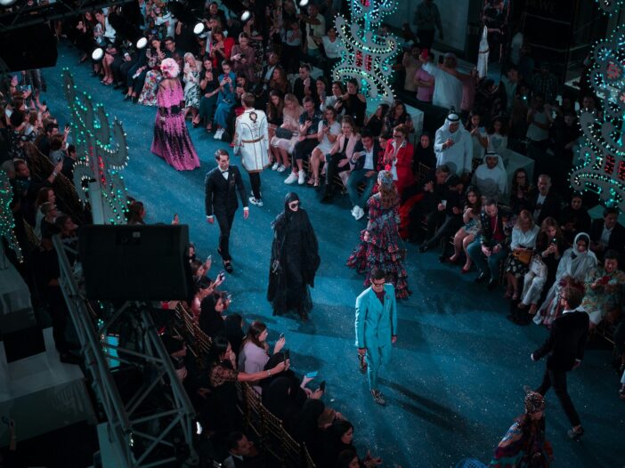Models walking down the runway at a fashion show, capturing the fast-paced world of fashion journalism.