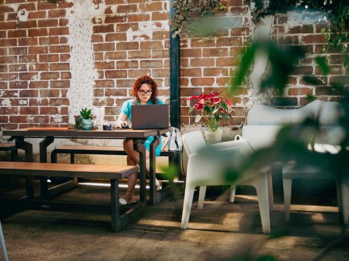 Woman at her laptop comparing freelance writing rates for new projects.