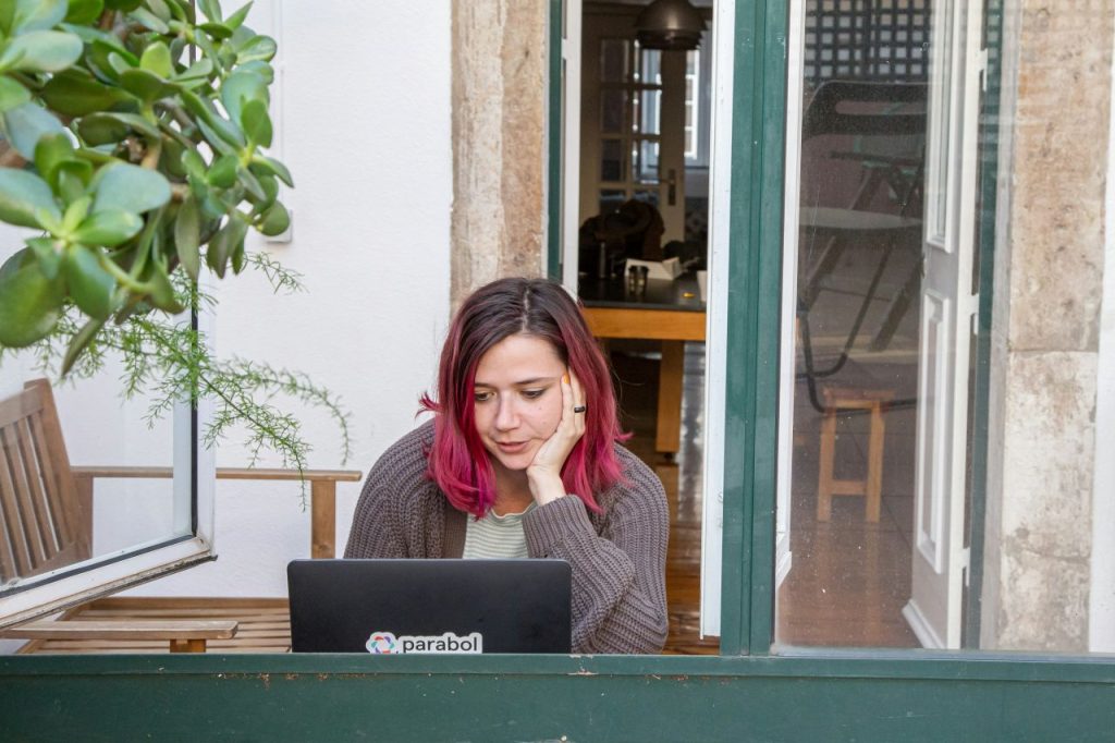 Pink-haired writer looks at her screen, mapping out how to publish a book.