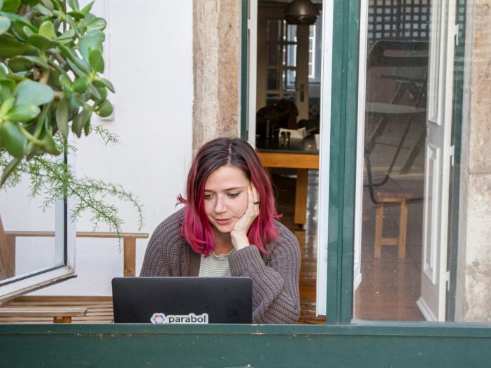 Pink-haired writer looks at her screen, mapping out how to publish a book.