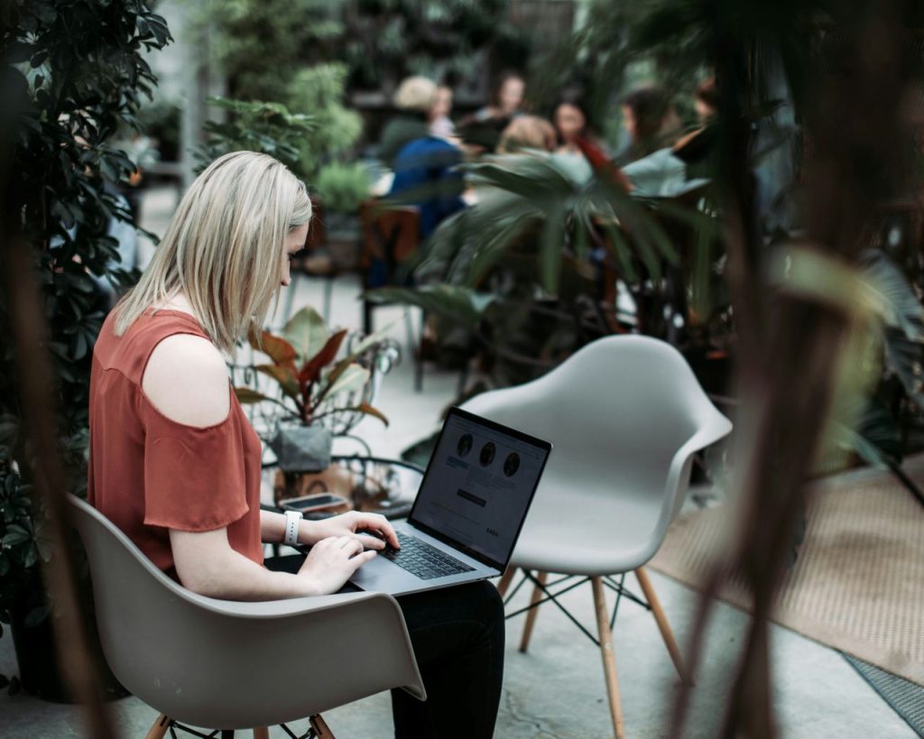 Woman at her laptop, sending a polite reminder about an outstanding invoice.