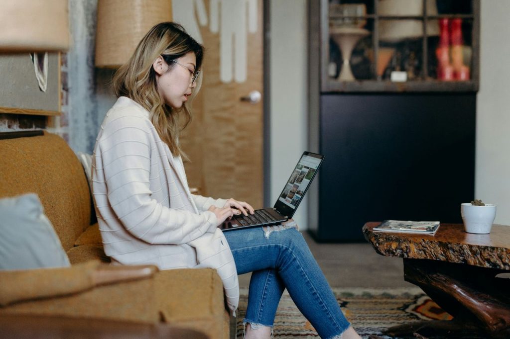 Laptop balanced on her lap as woman negotiates a fair rush fee.
