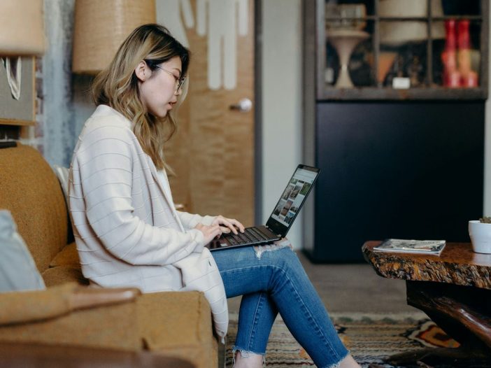Laptop balanced on her lap as woman negotiates a fair rush fee.