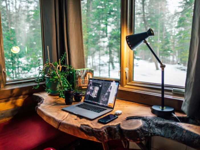 A computer in a warm, cozy space, reflecting the quiet yet persistent presence of self-criticism in a writer’s creative process.