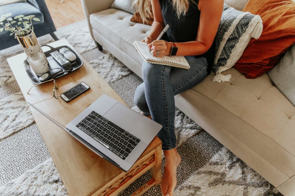 Focused on her next chapter, a writer prepares a book proposal on the couch.