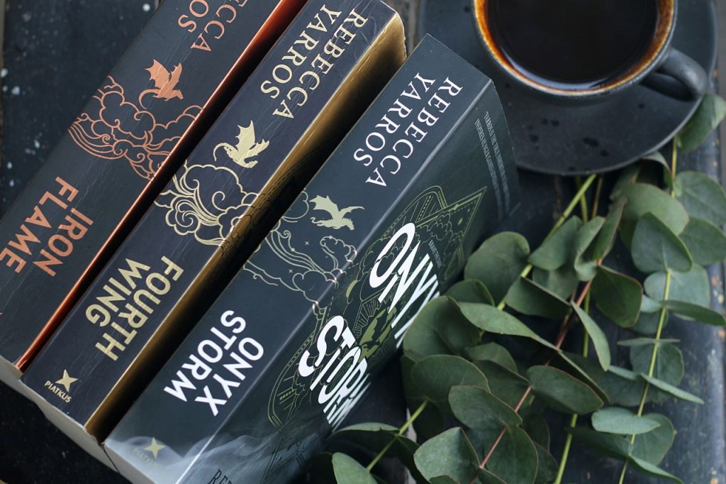 Stacked novels with coffee, perfect for escaping into romantasy worlds