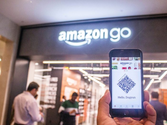 Phone held up against Amazon branding—symbol of self publishing on Amazon.