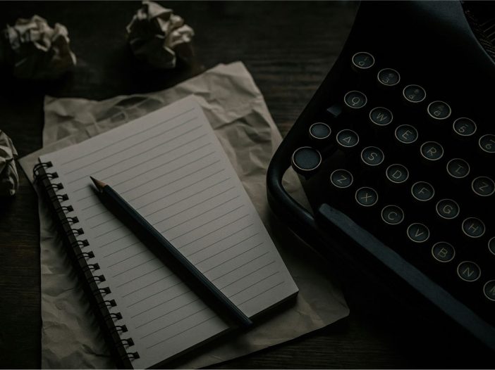 Crumpled drafts on a wooden desk, reflecting the frustration of finding short story ideas.