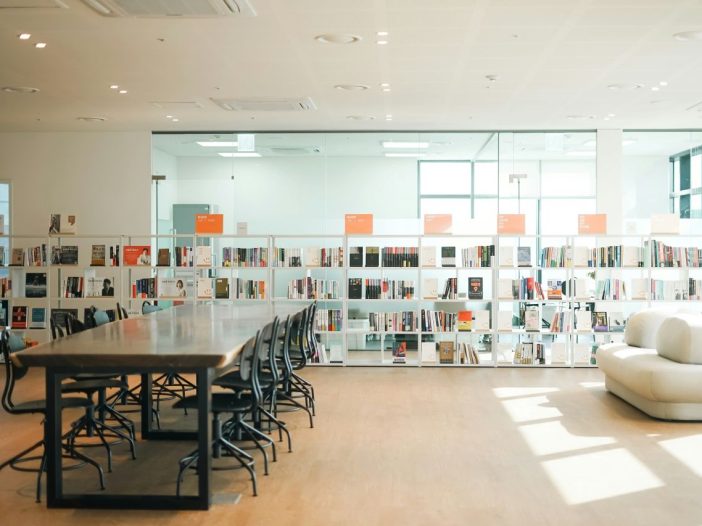 A long table in a book-lined office, where writers can learn how to write a query letter.